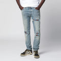 AMIRI MX1 distressed flannel-patched jeans in medium indigo